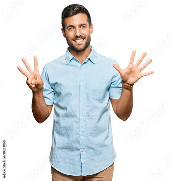 Fototapeta Handsome hispanic man wearing casual clothes showing and pointing up with fingers number eight while smiling confident and happy.