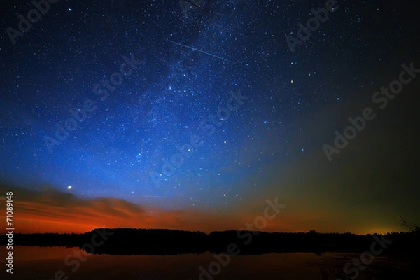 Obraz Morning dawn on a starry background sky reflected in the water o