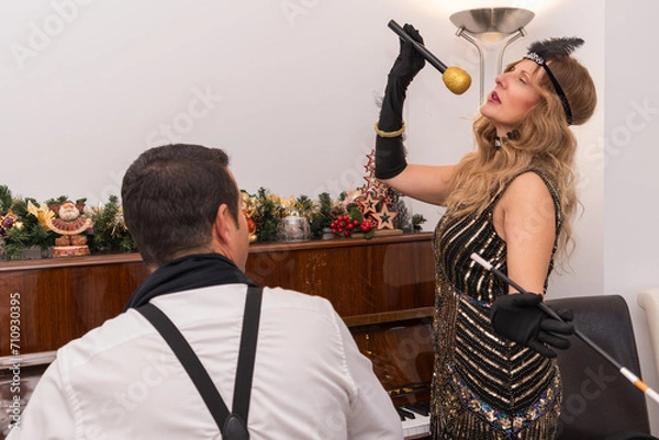 Fototapeta A man pianist plays while the woman sings dressed in Charleston style