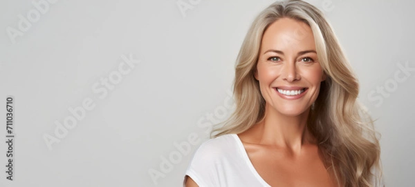 Fototapeta Beautiful middle-aged woman on a gray background.