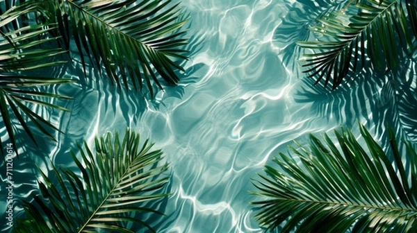 Fototapeta Spa concept with a palm leaf in wavy water. Abstract, transparent tropical water texture surface with palm leaves. top view, beauty backdrop, mockup, spa and wellness, copy space