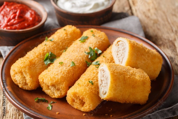 Fototapeta Polish Krokiety or croquettes stuffed with meat closeup on the plate on the wooden table. Horizontal