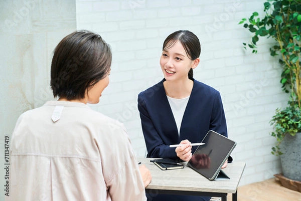 Fototapeta 私服の女性に説明するスーツ姿の女性