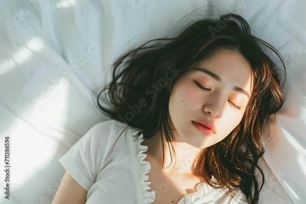 Fototapeta ベッドで寝ている日本人女性のポートレート（睡眠・うたたね・寝る・快眠・休息）