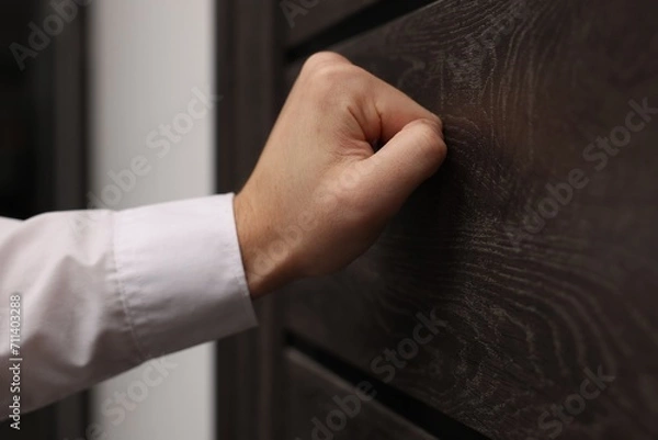 Fototapeta Collector knocking on door indoors, closeup view