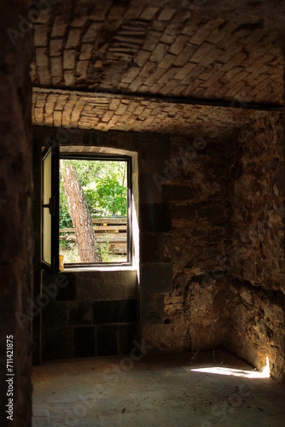 Fototapeta stone basement in an old house during restoration. An open window to the garden.