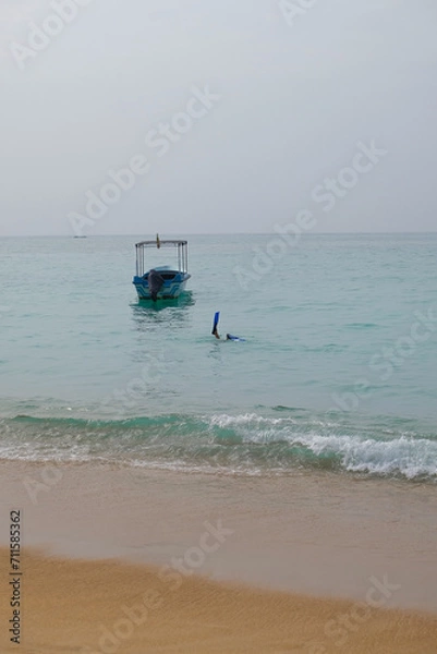Fototapeta Person in fins dived under the water, a leg in a fin sticks out of the water