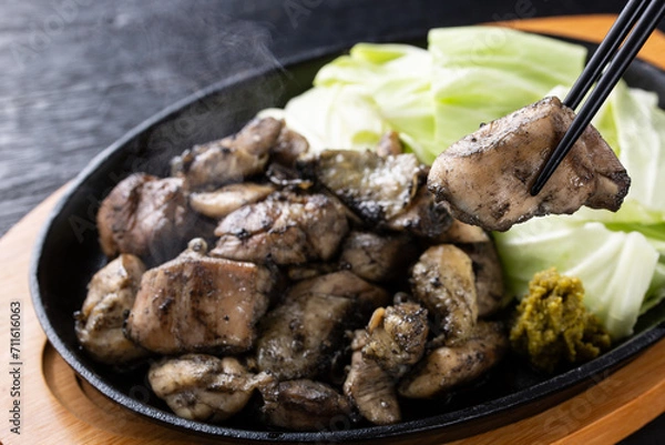 Obraz 地鶏焼きを箸で食べる