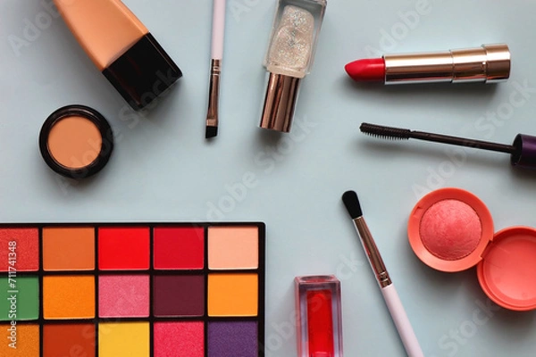 Fototapeta Various colorful make up products on bright blue background. Flat lay.