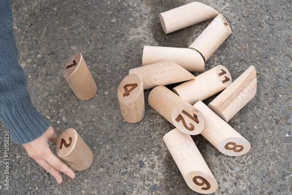 Fototapeta モルックの散らばったスキットルを並べる女性