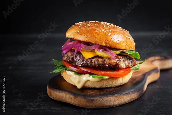 Fototapeta Beef hamburger. Sandwich with beef burger, tomatoes, cheese, pickled cucumber and lettuce. Cheeseburger.