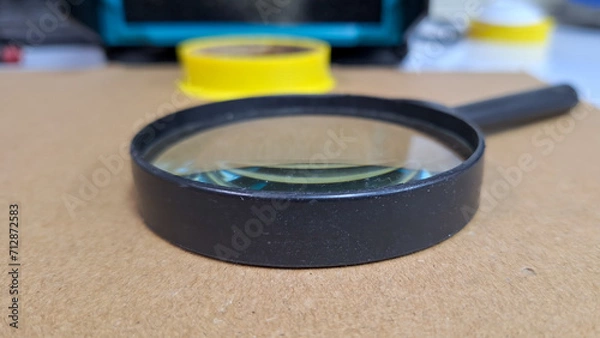 Fototapeta Old magnifying glass on the desk.