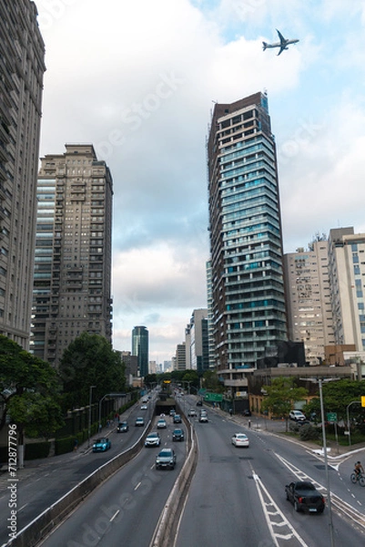 Fototapeta Urban landscape of the city of São Paulo with plane over the buildings, Brazil. Avenida Cidade Jardim.
