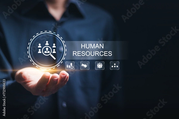 Fototapeta Businessman hold virtual HR word with human resources icon for recruitment process to work efficiently and achieve sustainable business success. team building. Human Resources HR management concept.