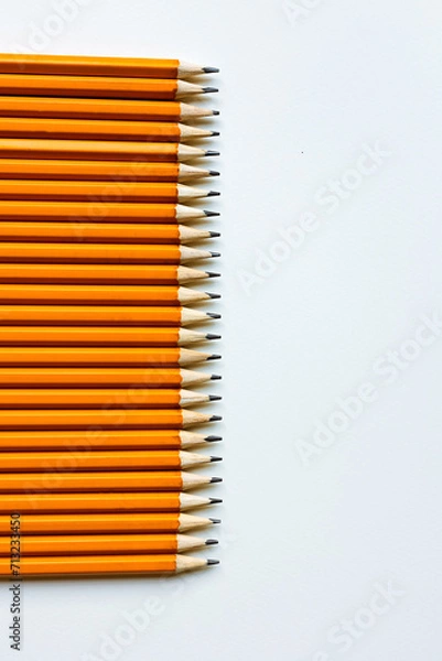 Fototapeta Yellow simple pencils lie on a white background.