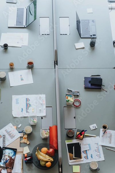 Fototapeta Busy creative office desk with laptops, tablets, and healthy snacks.