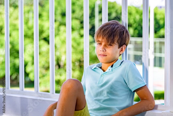 Obraz Handsome smiling teenager's portrait on green garden background
