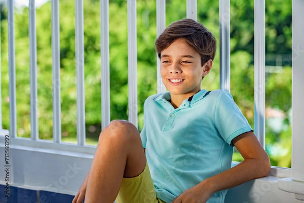Obraz Handsome slyly smiling teenager's portrait on green garden background