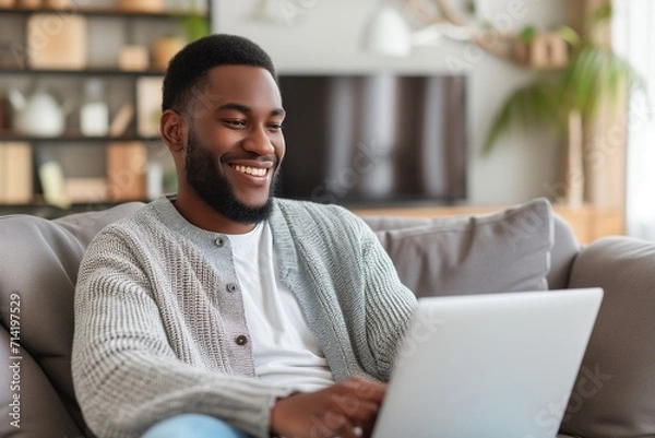 Obraz Smiling Man Using Laptop in Cozy Living Room