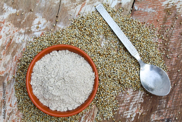 Obraz Pearl millet powder in a bowl with seeds on wooden background 