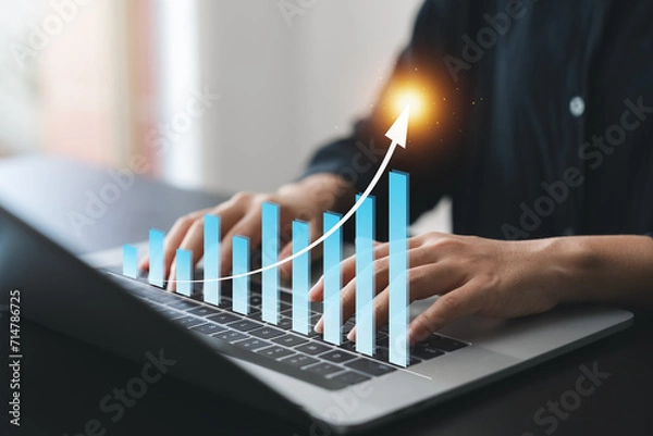 Fototapeta Businesswoman use laptop and tablet analyzing company growth, future business growth arrow graph, development to achieve goals, business outlook, financial data for long term investment.
