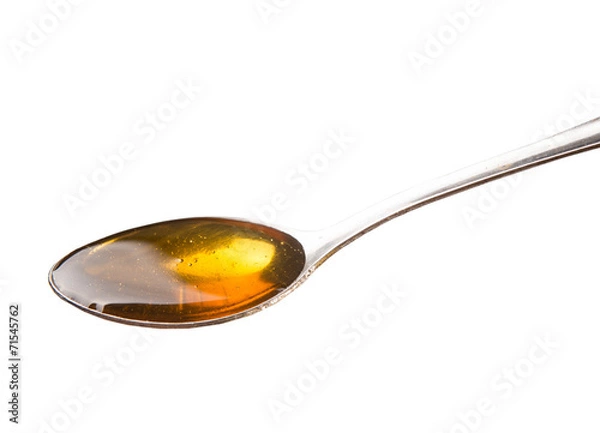Fototapeta A spoon of honey over white background