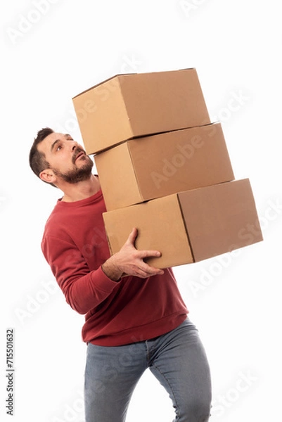 Fototapeta Man with red sweater and white background holding boxes and trying not to drop them. Help for home delivery. Solution for moving problems. Shipping service