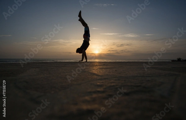 Obraz silhouetted man doing handstand in sunset
