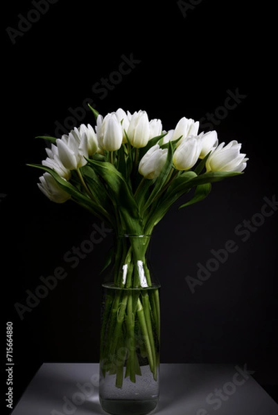Obraz A bunch of white tulips on black background in transparent glass vase