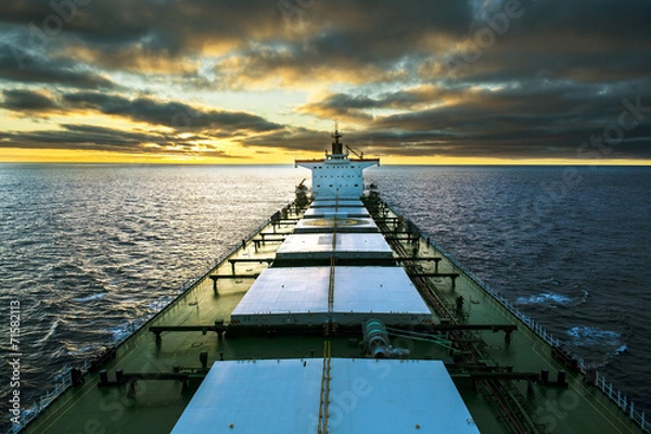 Obraz Cargo ship underway at sunset