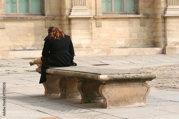 Fototapeta Jeune femme assise sur un vieux banc en pierre