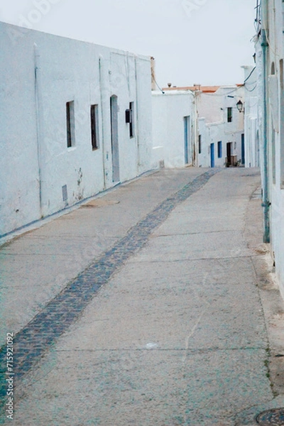 Fototapeta Lone street of an Andalusian town whitewashed with no inhabitants and no sign of life
