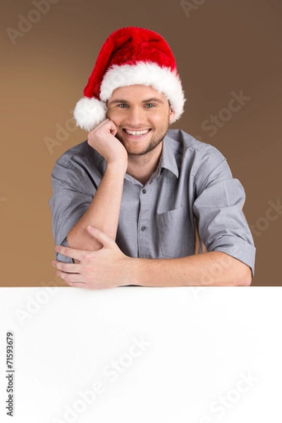 Fototapeta young man looking into camera with blank panel isolated