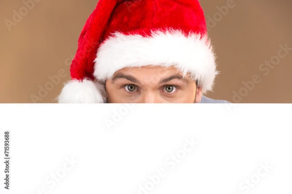 Fototapeta young man looking into camera with blank panel isolated