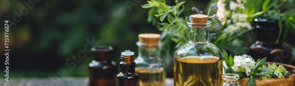 Obraz Natural organic essential oil in small glass bottles on wooden background. Homemade production for spa, sauna, bath. Relaxation, alternative medicine, remedy, naturopathy, pure ingredients