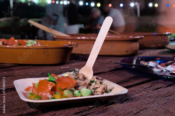 Fototapeta Mediterranean salad on a wooden table during a party