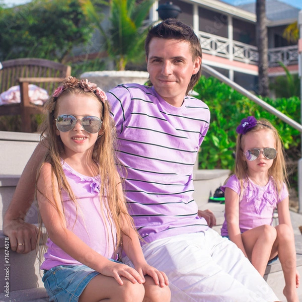 Fototapeta Family of three sitting on beach enjoying ocean view