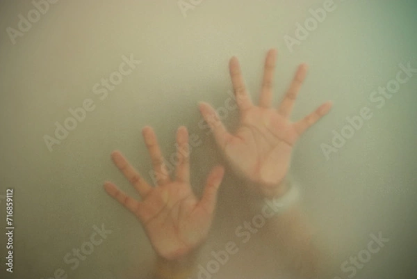 Fototapeta Silhouette hands behind the mirror Abstract style, One hand on a glass partition with blurry. Illustration of designer