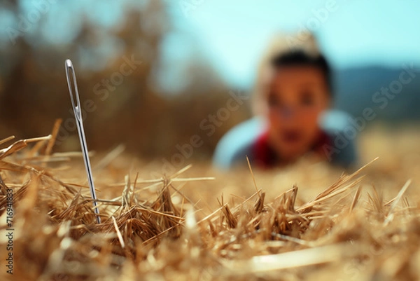 Fototapeta Close-up of a needle in a haystack with a blurred background of a person looking for it with a satisfied face. "it's harder than finding a needle in a haystack."