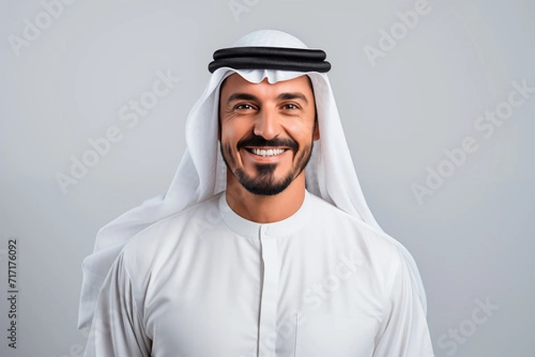 Fototapeta Portrait of an Arab man wearing keffiyeh, smiling and looking at the camera. White background, isolated. Generative AI.
