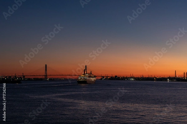 Obraz 夕暮れの港を出港する大型客船