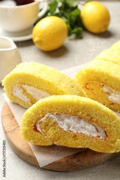 Fototapeta Delicious cake roll with cream filling on grey table, closeup
