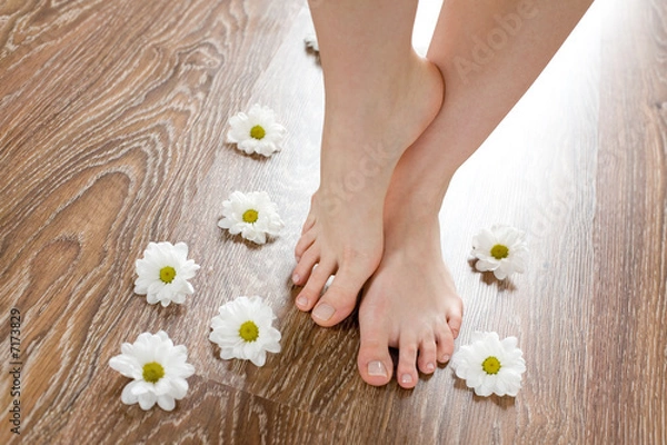 Obraz Female feet on the dark floorboard