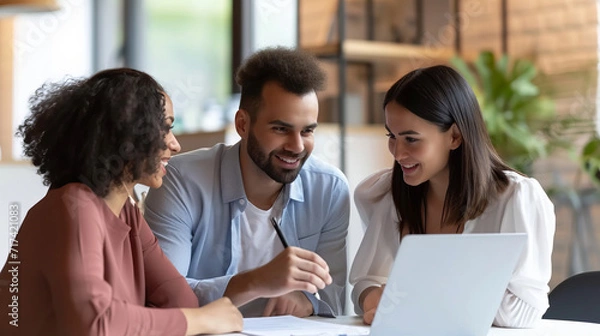 Fototapeta A diverse team collaborating over a laptop in a bright office space, representing modern teamwork is AI Generative.