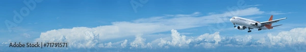 Obraz Jet plane in a blue cloudy sky
