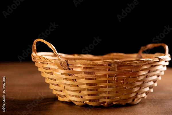 Fototapeta Straw basket, beautiful straw basket on rustic wooden table, selective focus.