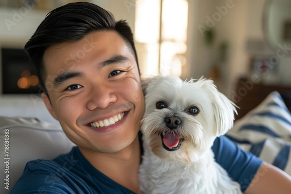 Obraz Happy asian man hugging his shih tzu dog in a living room