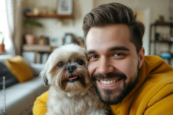 Obraz Happy brunette man hugging his shih tzu dog in a living room