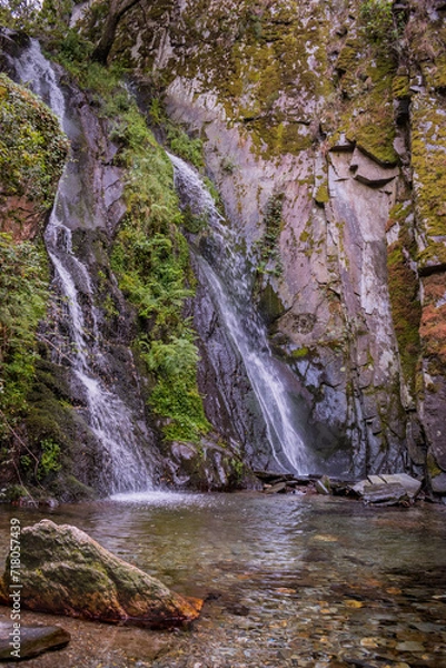 Obraz Motion of blurred water falling on schist stones with vegetation into a small lagoon in Fraga da Pena, Pardieiros - Arganil PORTUGAL