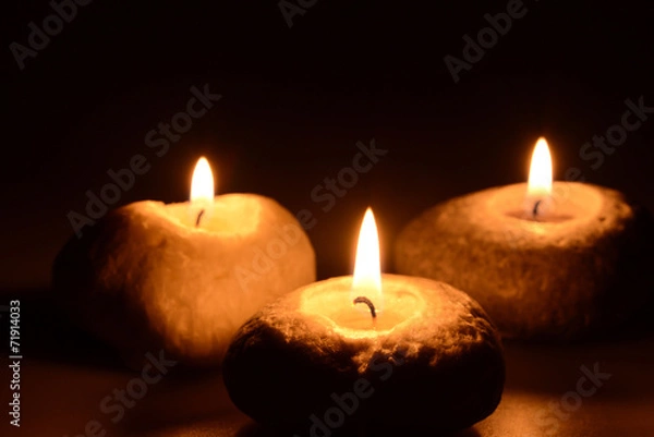 Obraz Three candles on a black background